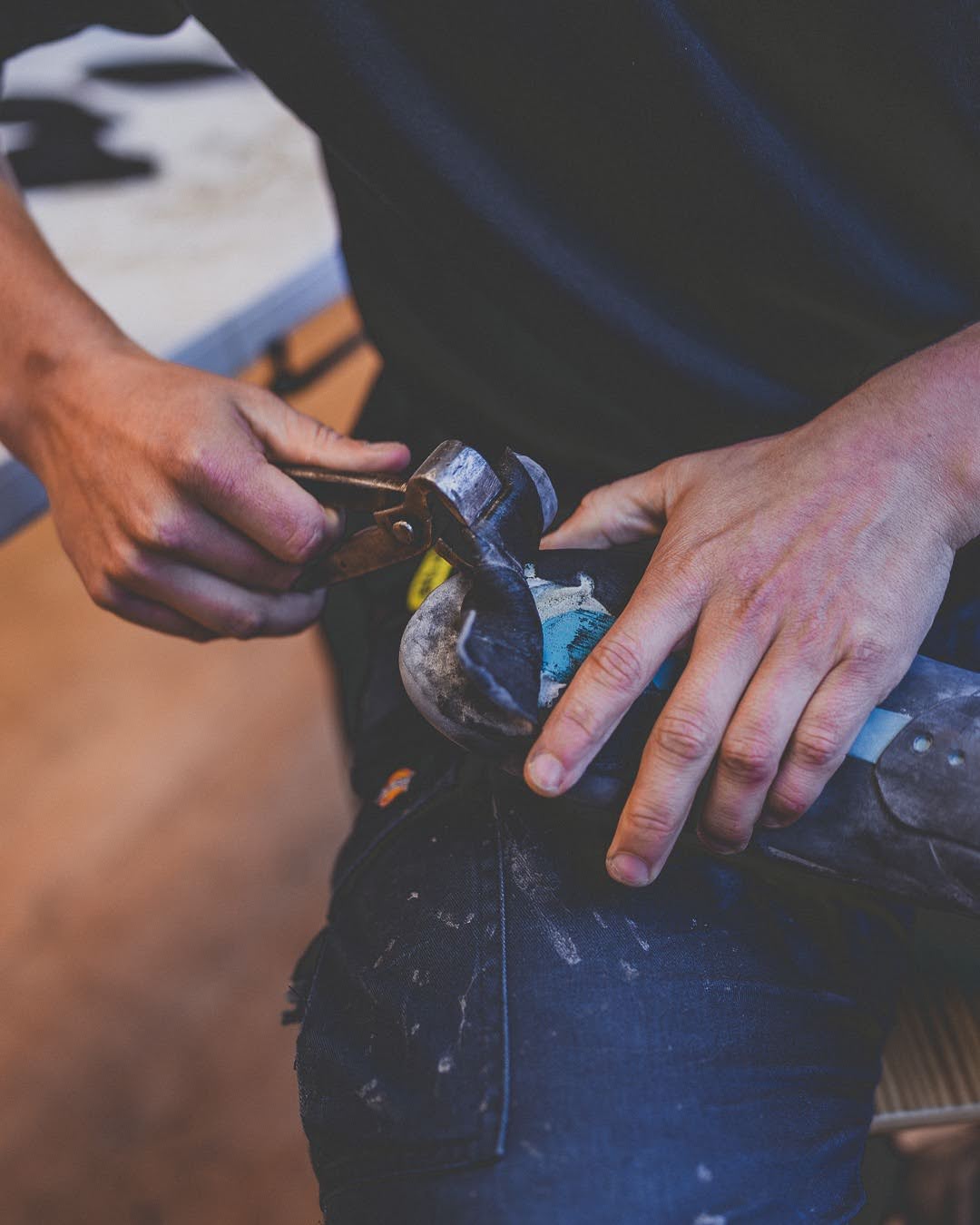 Hands trimming and patching rubber on a climbing shoe